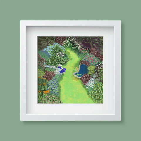 A framed art print depicting a woman enjoying her beautful garden and pond, presented in a white frame