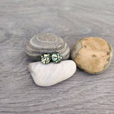Claire Fernig Spinnaker Glass Golden Crackle 925 Silver stud dichroic earrings on beach pebbles