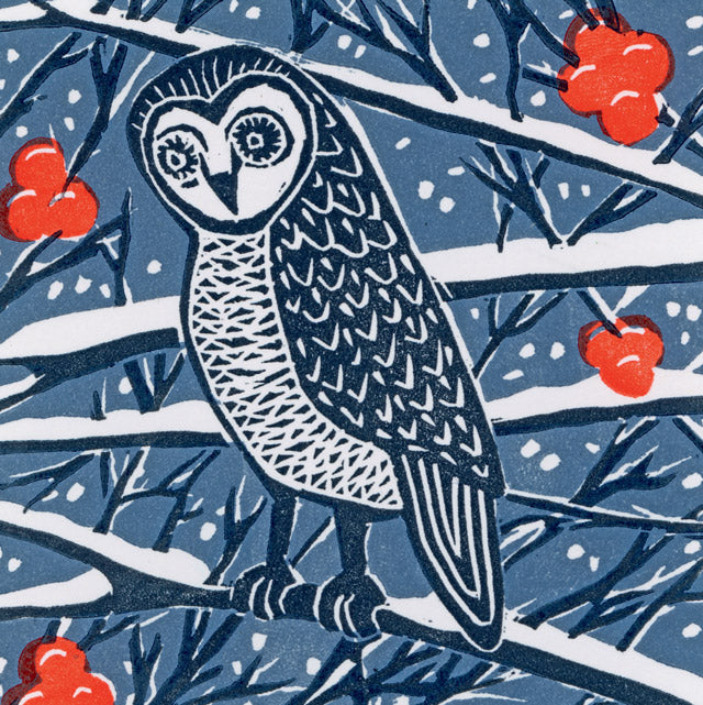 A stylized winter illustration by prinmaker Kate Mawdsle of an owl perched on a snowy branch, with red berries and dark blue tree branches on a blue background.