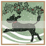 A square art print featuring a black dog silhouette running beneath a green holly branch with red berries, set against a pale green snowy background with white stripes and snowflakes.