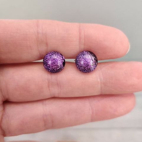 Claire Fernig Spinnaker Glass Gold Purple  dichroic glass 925 Silver stud earrings held between fingers