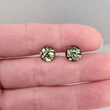 Claire Fernig Spinnaker Glass Golden Crackle 925 silver dichroic  stud earrings held between fingers